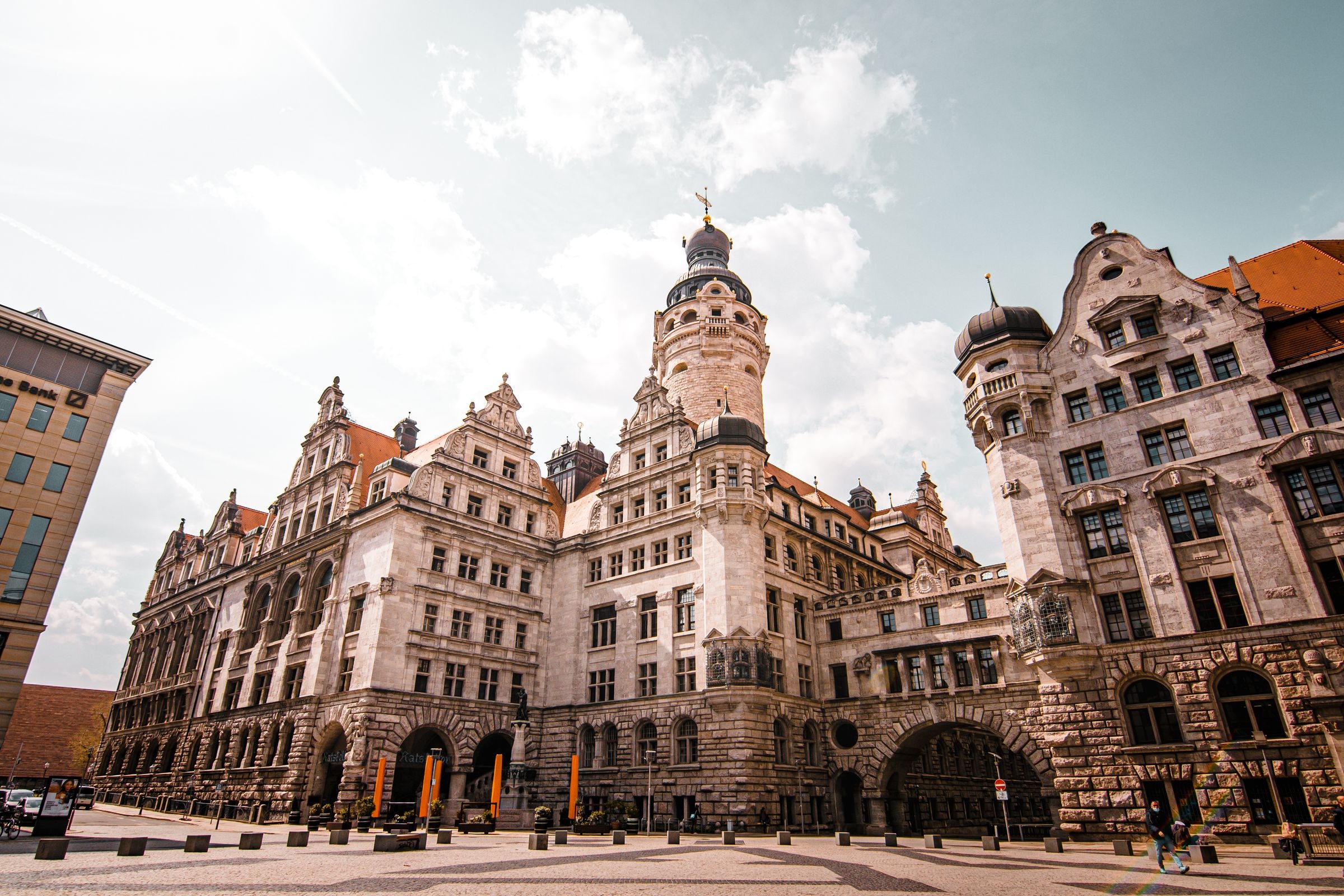 Monumental ayuntamiento histórico con torres ornamentadas junto a una plaza adoquinada
